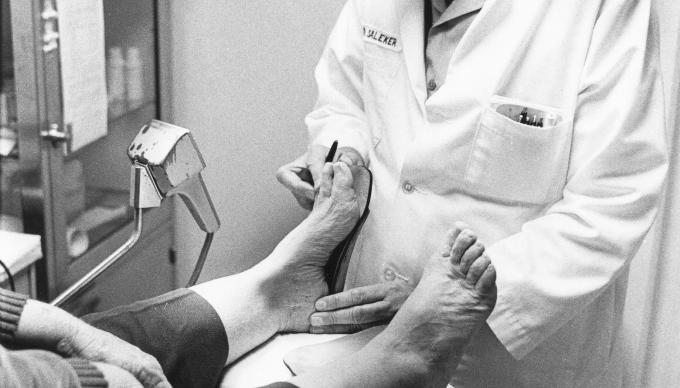 Clinician examining a patient's foot during a medical assessment