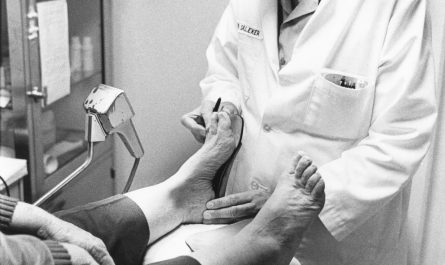 Clinician examining a patient's foot during a medical assessment